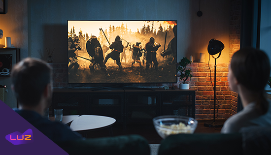 pessoas assistindo filme de ação na televisão